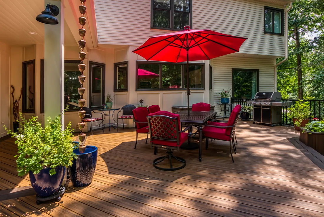 Rain chain hanging from deck in Northern VA backyard with red outdoor patio set