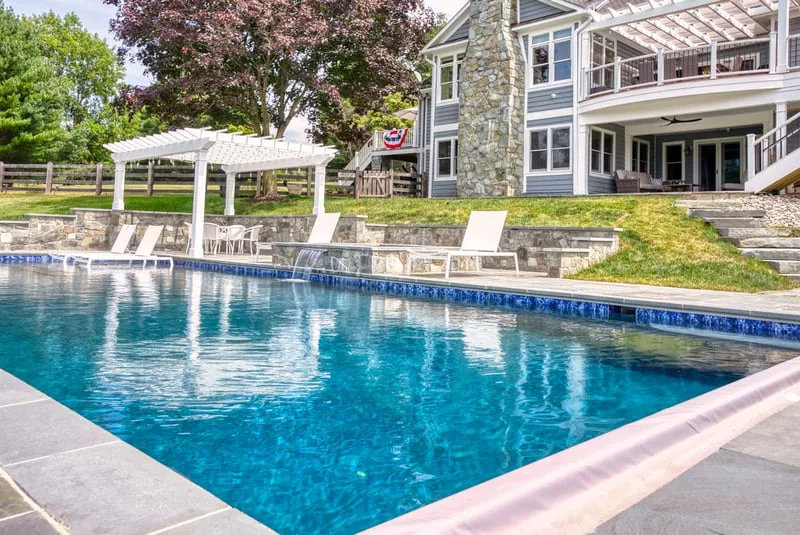 In-ground gunite pool by Deckscapes of VA with tanning ledge and waterfall feature