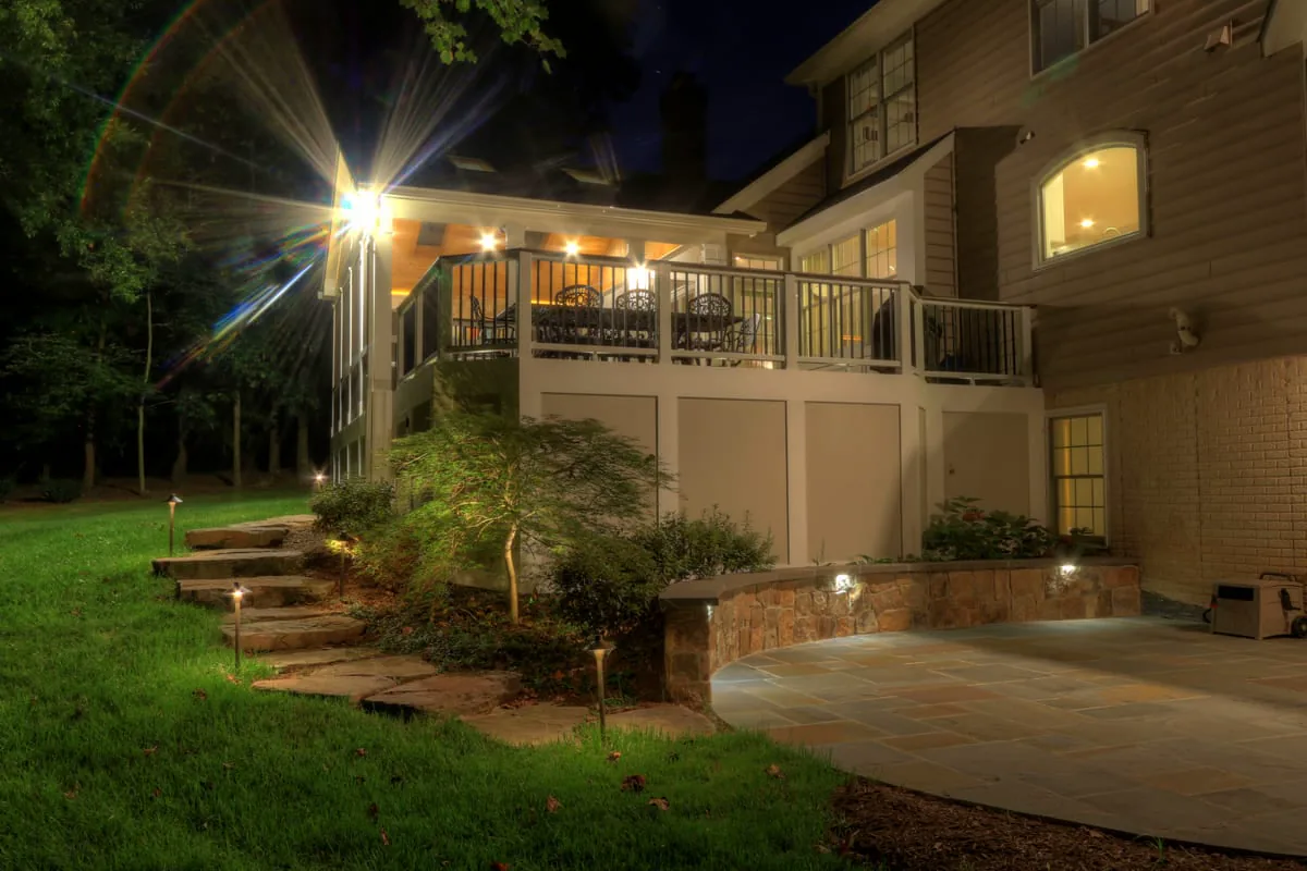 Chantilly, VA patio and steps leading to deck at night with custom lighting by Deckscapes of Virginia