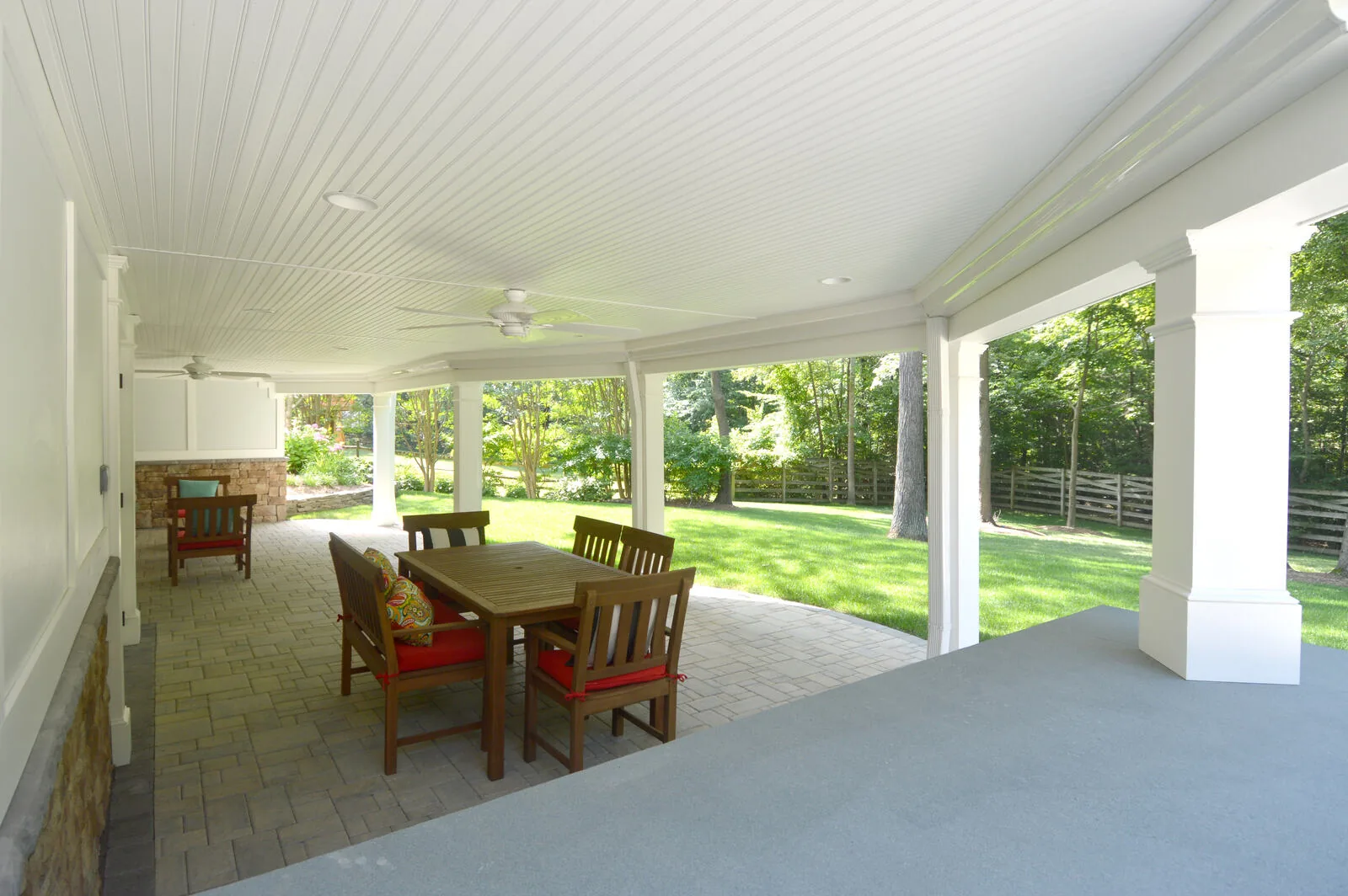 White under deck drain system with table and chairs and white ceiling fan