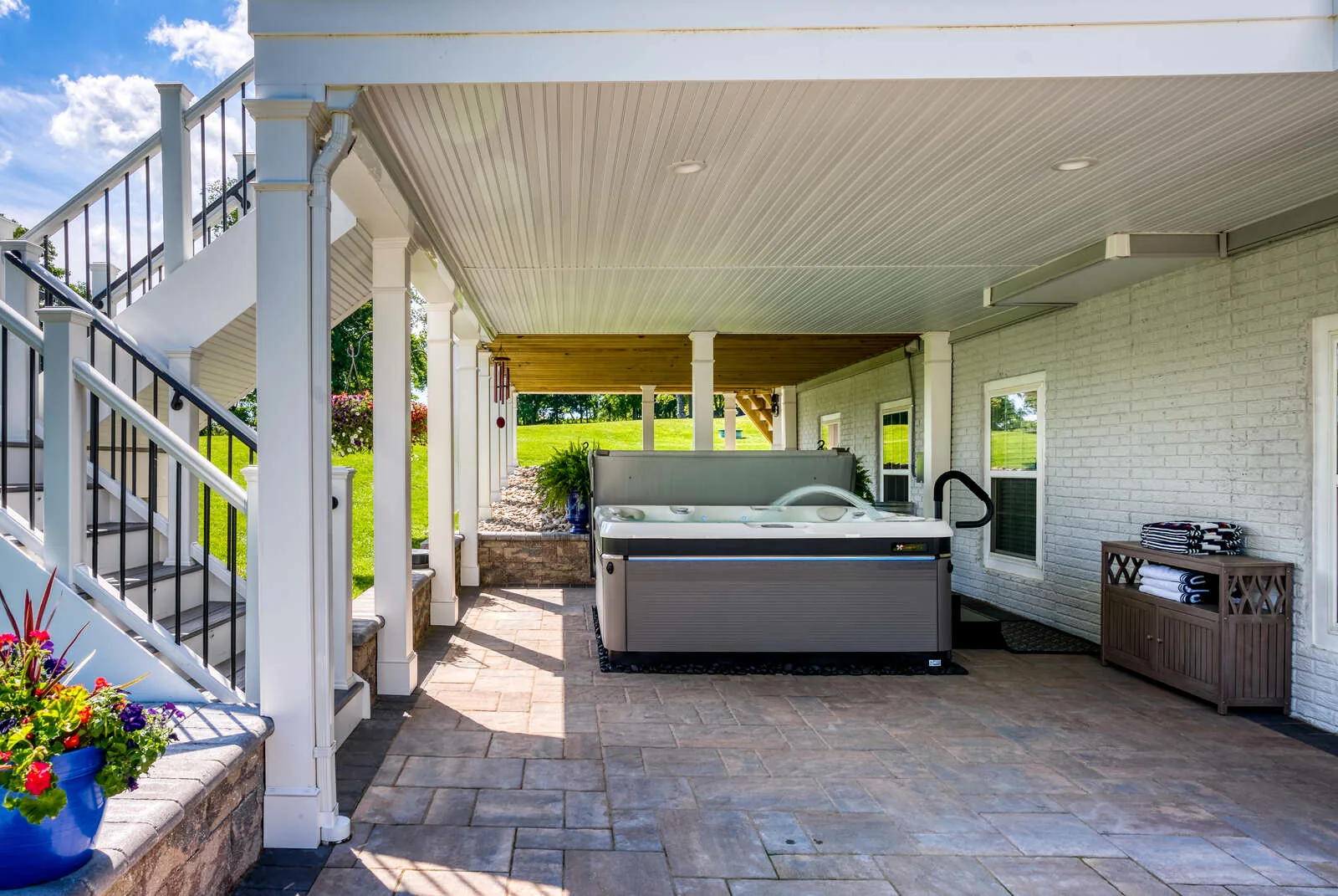 Under deck drainage system with hot tub under deck