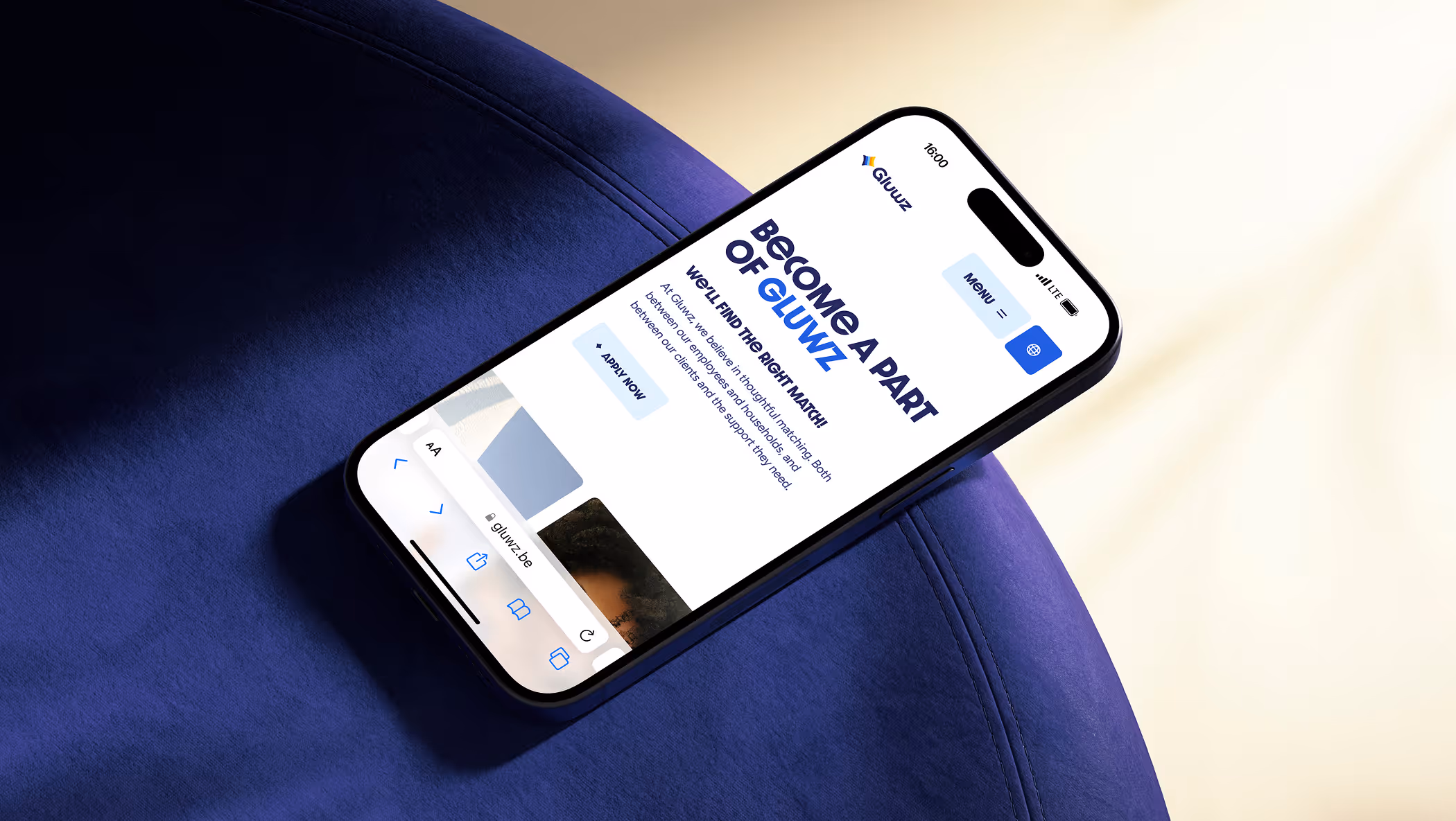 Smartphone showing Gluwz website with text 'Become a part of Gluwz' and a call to action button to apply now, placed on a blue cushioned surface.