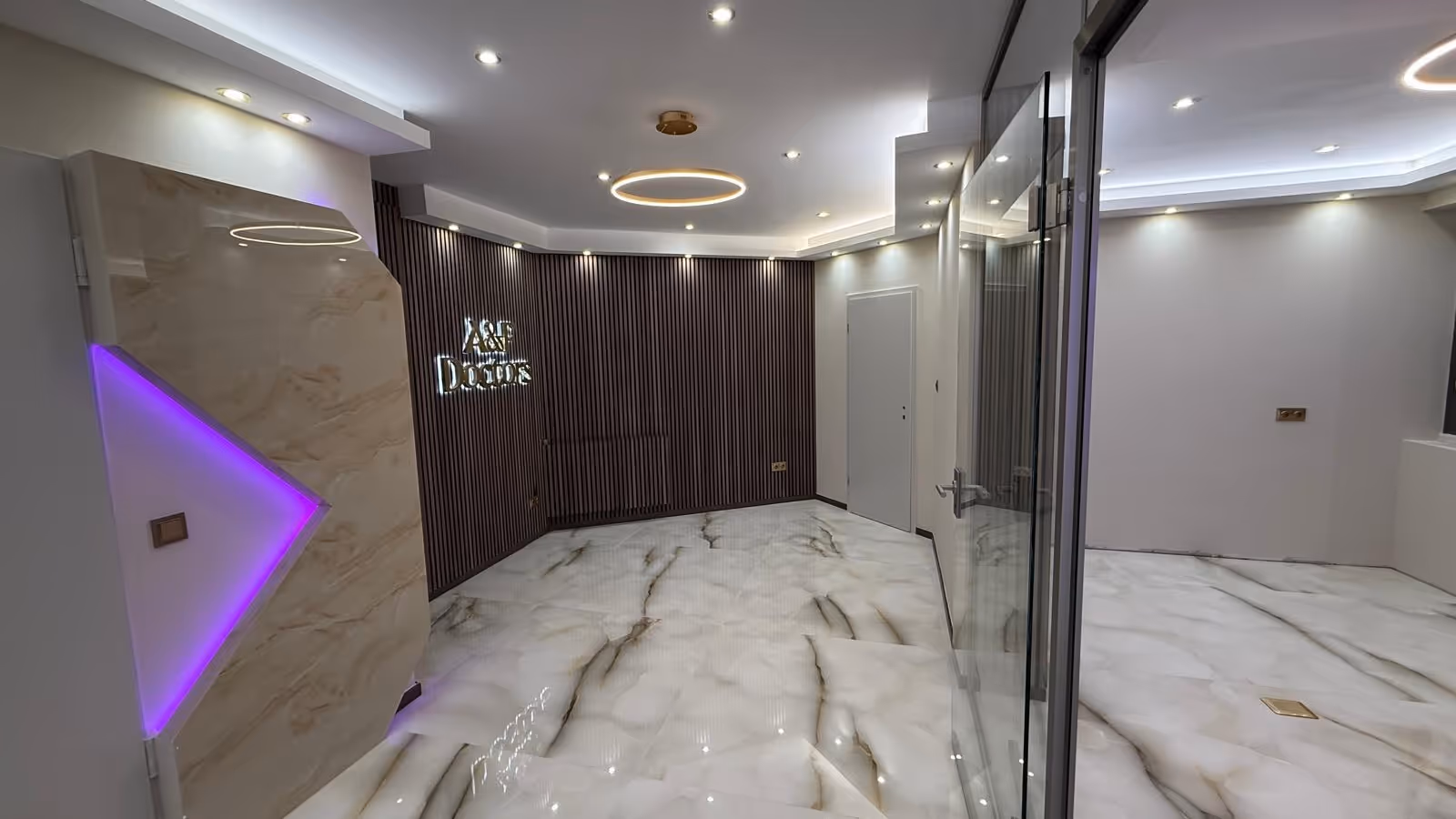 Modern interior with glossy white marble floor, vertical wooden slat wall with illuminated 'A&P Doctors' sign, and glass door.