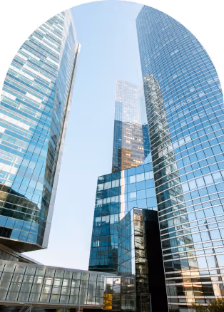 Cluster of modern glass skyscrapers reflecting the sky and surrounding buildings.