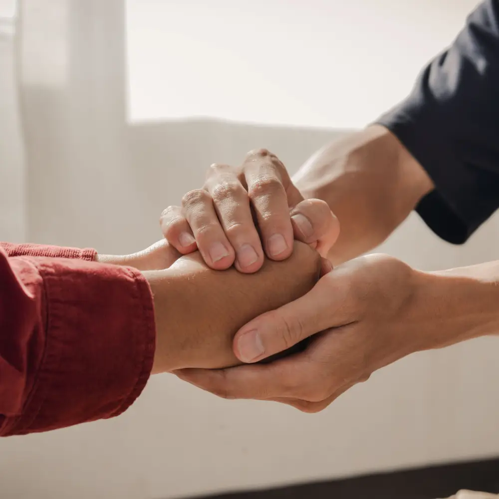 Supportive gesture between individuals representing compassionate mental health care and support services in Albuquerque