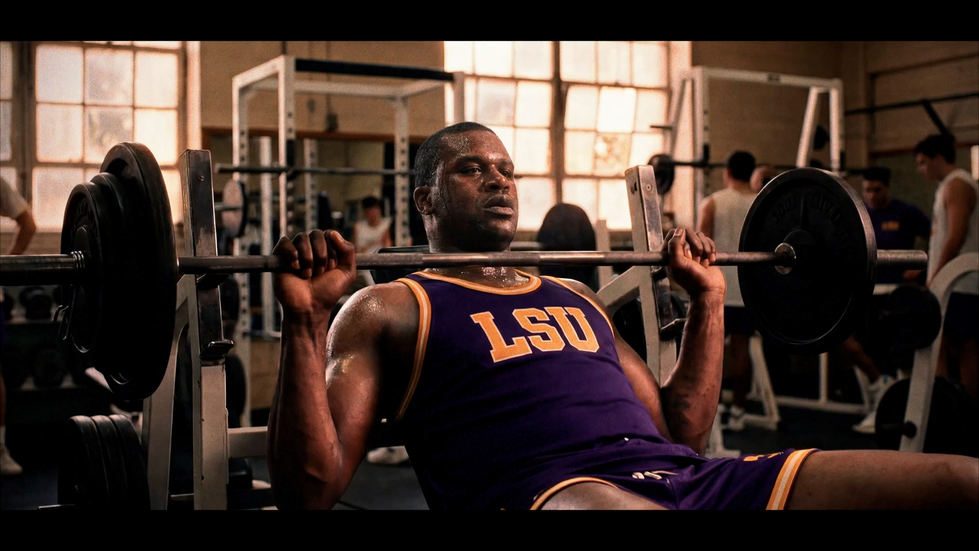 AI-generated frame of young Shaquille O'Neal bench-pressing in his LSU era