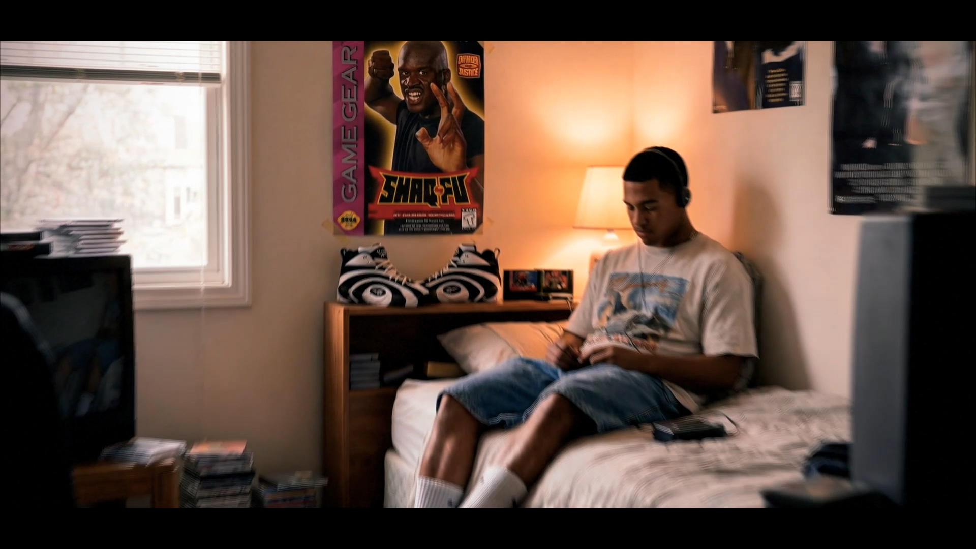 A kid's bedroom with a Shaq-Fu poster on the wall and sneakers on the dresser
