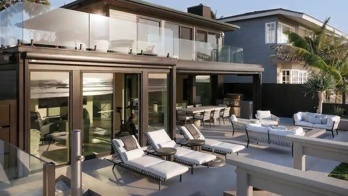 The outdoor deck and glass facade of the oceanfront home