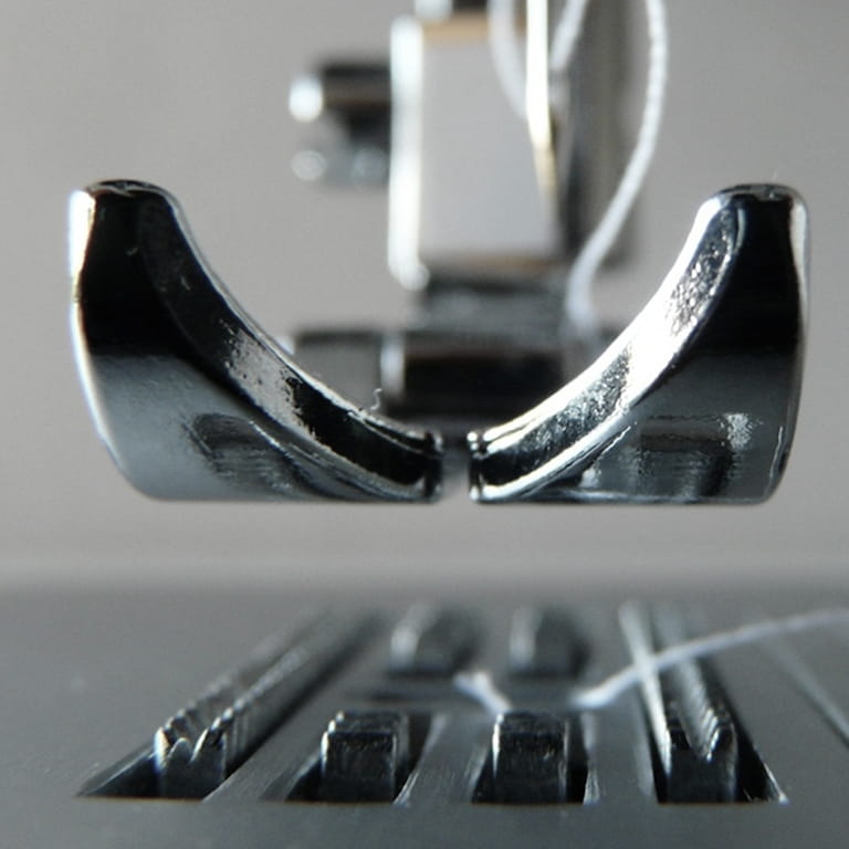 Close-up of a sewing machine presser foot holding fabric and needle above the feed dogs.