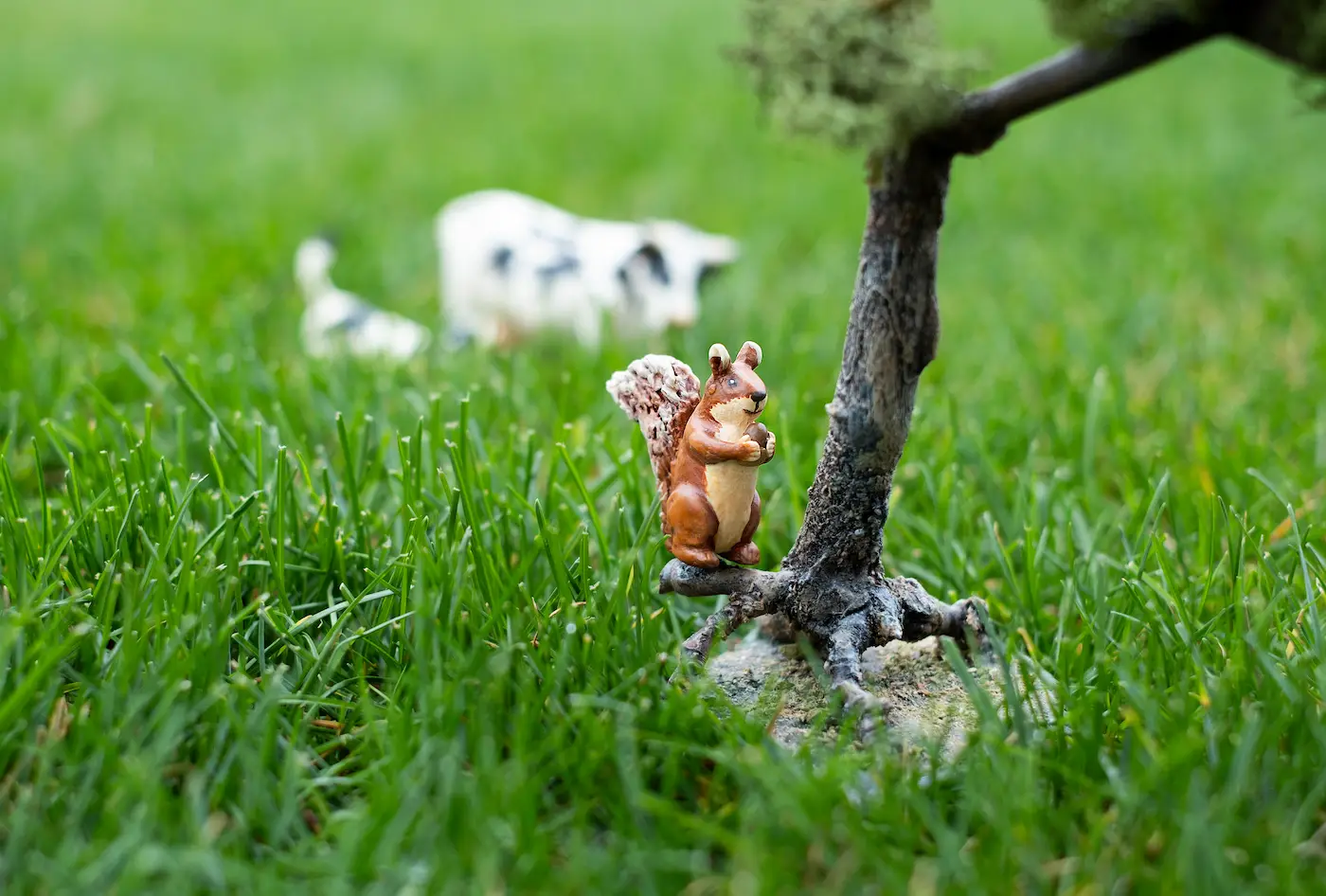 La misma figura de ardilla fotografiada con una apertura abierta: la figura sale nítida y la vaca del fondo queda desenfocada