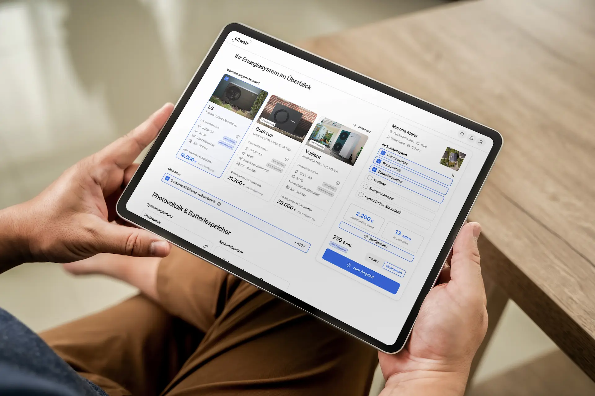 Tablet zeigt eine Energiesystem-Übersicht mit Auswahl von Wärmepumpen, Photovoltaik und Batteriespeicher in einer deutschen App.