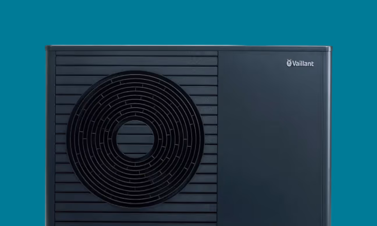 Schwarzes Außengerät einer Vaillant Wärmepumpe vor türkisem Hintergrund.