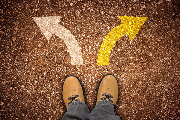 Choix entre deux directions symbolisées par des flèches au sol devant une personne