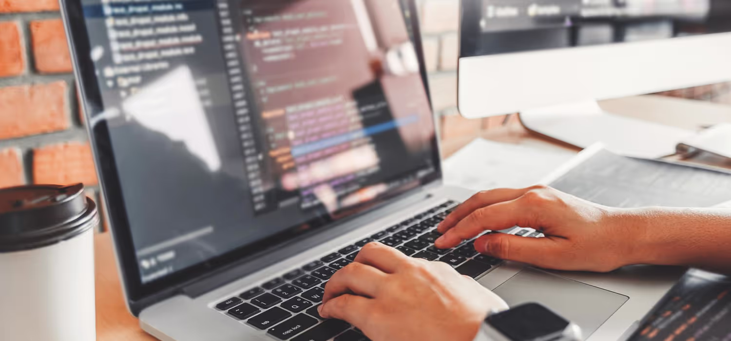Un développeur devant son pc occupée à coder une application front-end et back-end