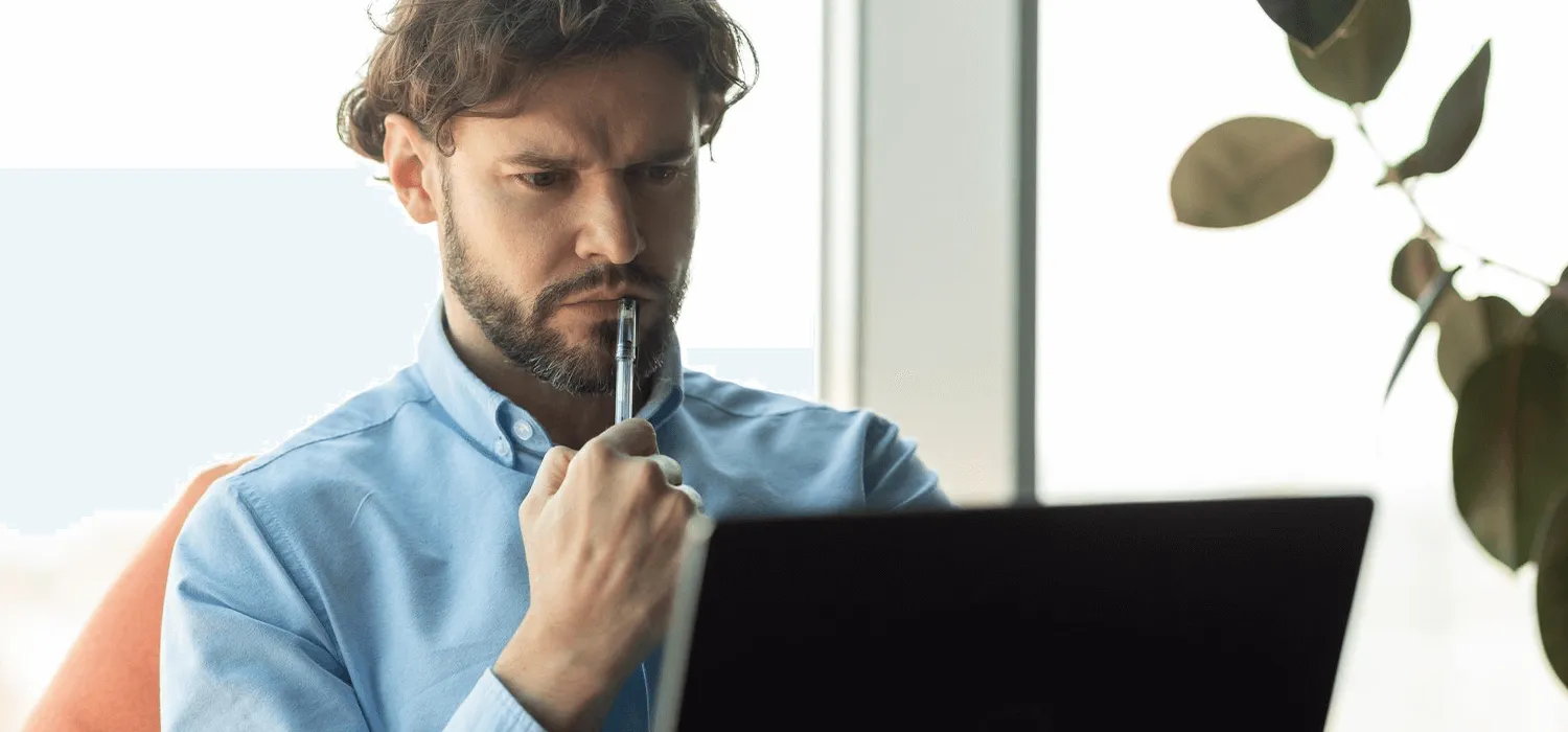 Un client face à son pc qui est occupé à réfléchir pour son site internet : le faire soi-même ou le confier à une agence web.