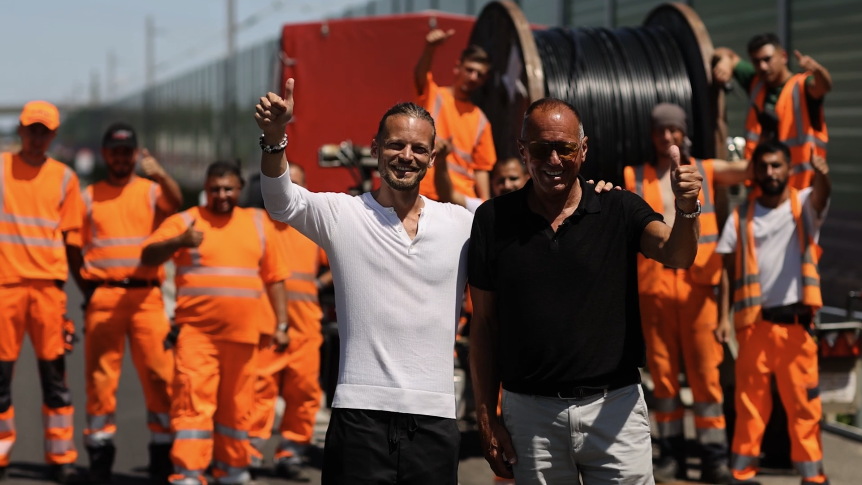 Team der Klefenz GmbH auf einer Baustelle mit Arbeitskleidung und Kabeltrommel im Hintergrund.
