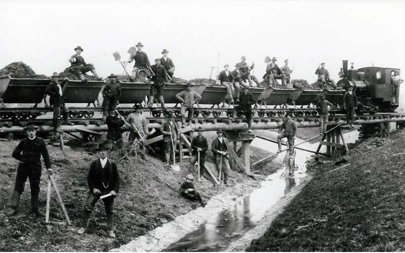 Historische Aufnahme früher Bauarbeiten der Klefenz GmbH mit Kipploren, Arbeitern und Lokomotive.
