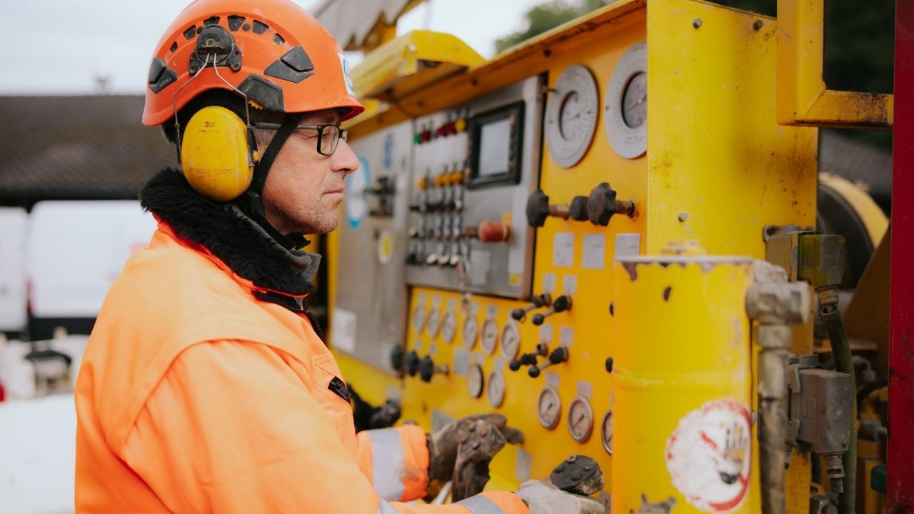 Mitarbeiter bedient die Steuerung einer Bohranlage auf der Baustelle.