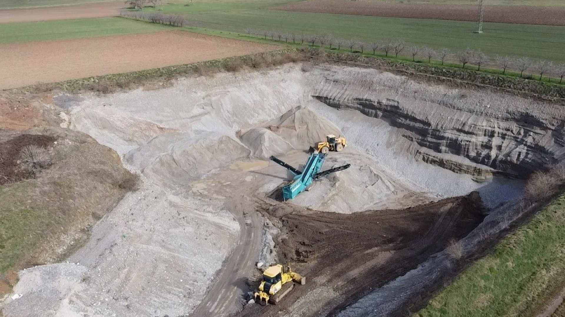 Luftaufnahme eines Rohstoffabbaus der Klefenz GmbH mit Baggern und Fördertechnik.