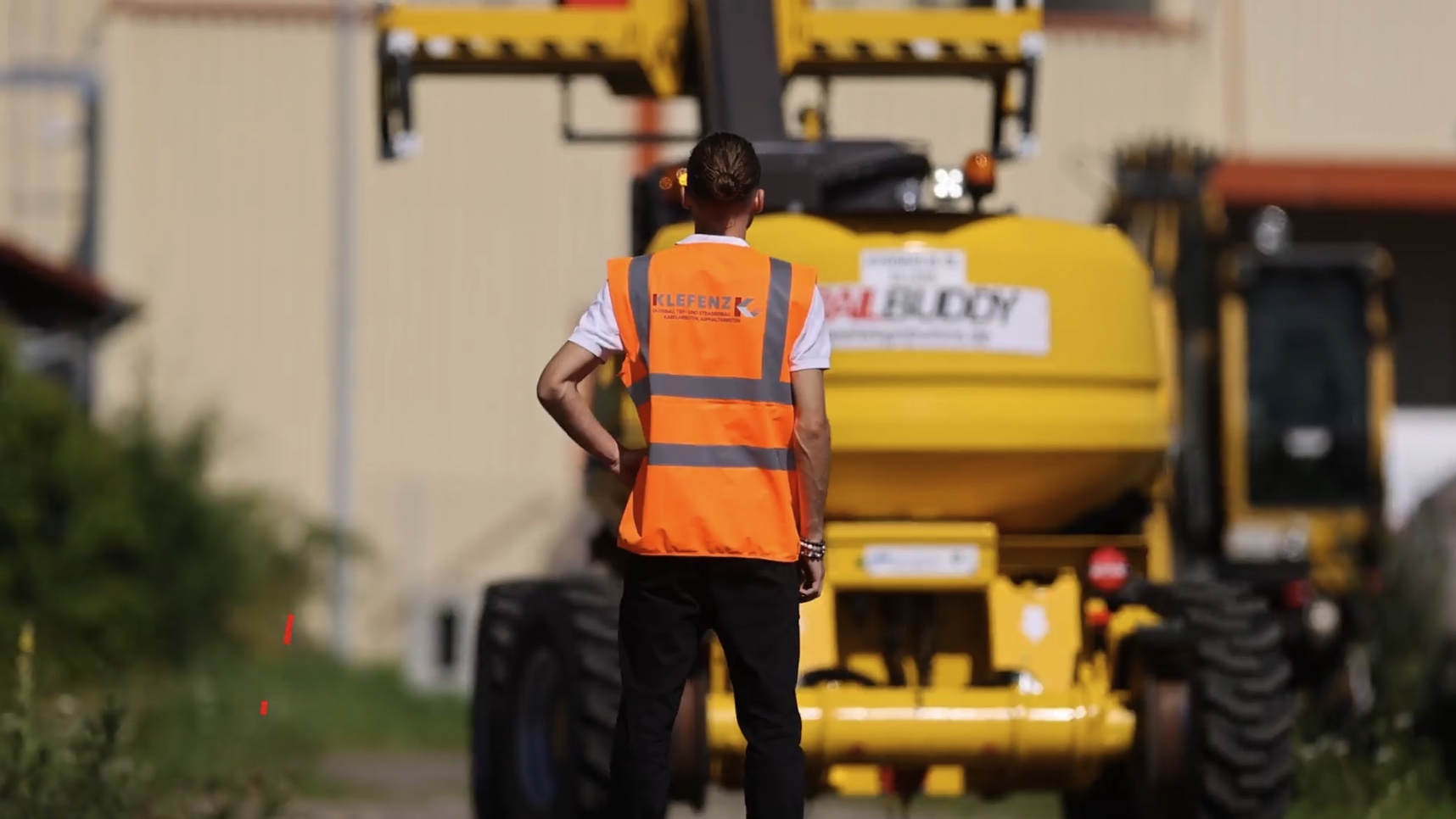 Mitarbeiter der Klefenz GmbH vor einer Baumaschine auf dem Betriebsgelände.