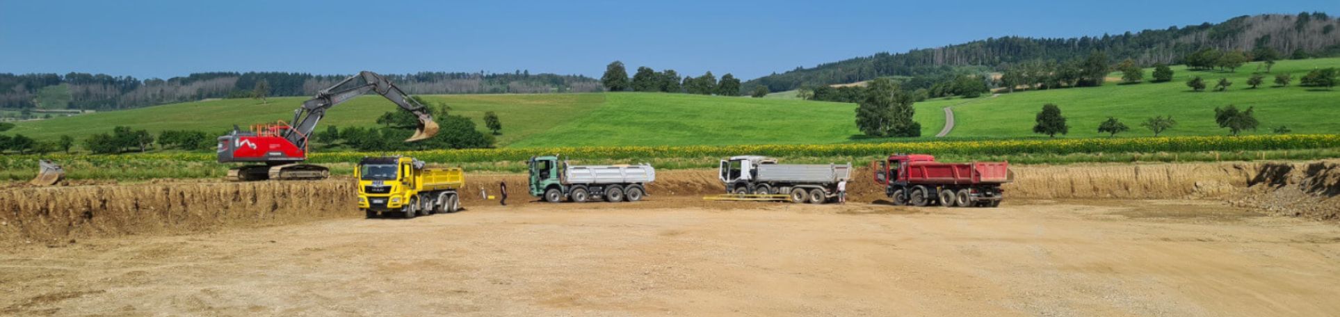 Materialtransport mit LKW und Radladern auf einer Baustelle