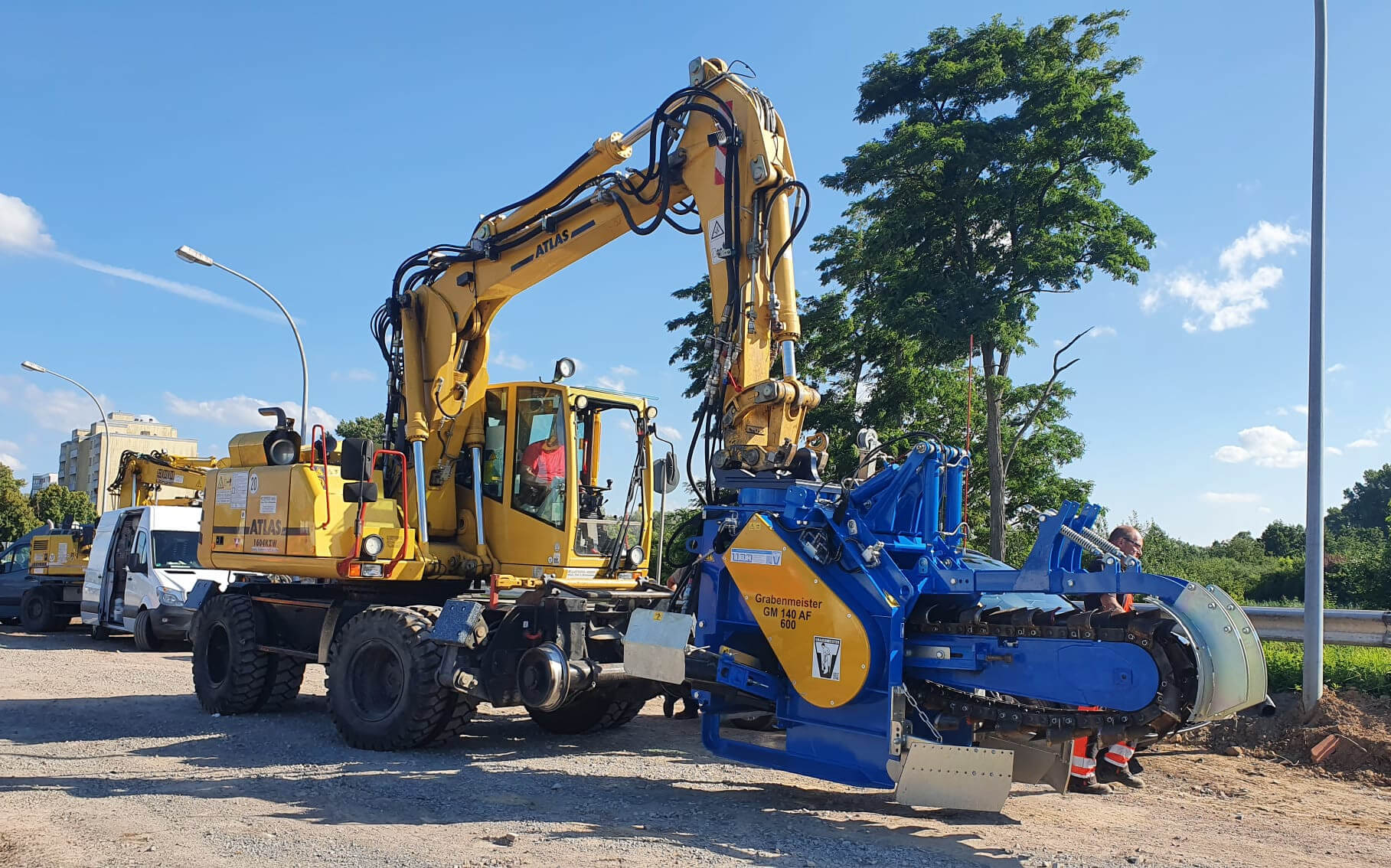 Bagger mit blauem Transportfahrzeug bei Bauablauf