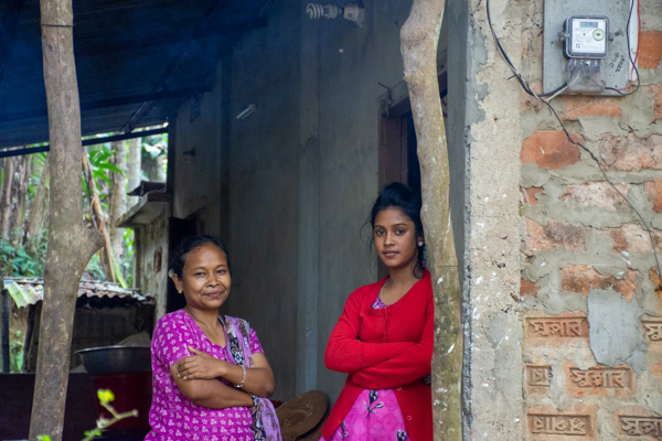 Tribe mother and daughter standing near door.