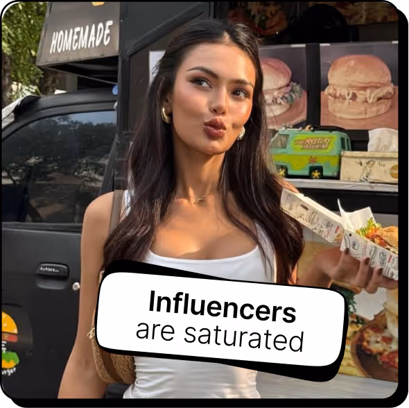 Young woman with long dark hair holding a food tray near a food truck with a sign that says 'Homemade' and a caption reading 'Influencers are saturated.'