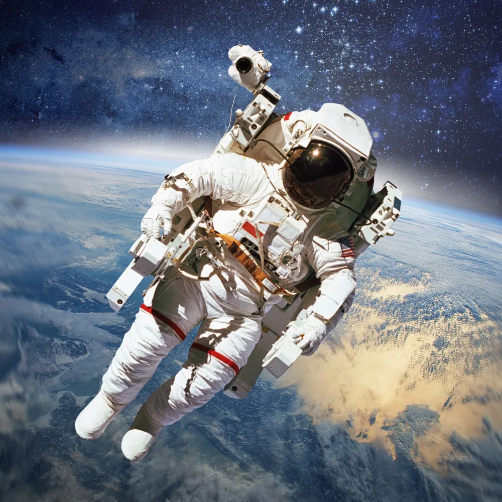 Astronaut in a white space suit floating in space with Earth and stars in the background.
