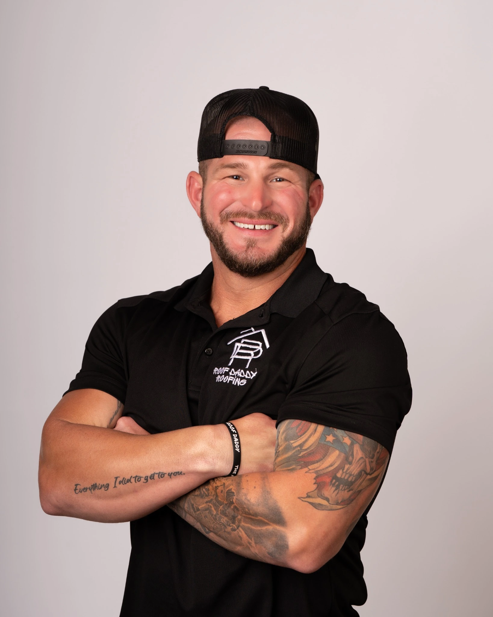 Nick from Roof Daddy Roofing smiling in a black branded polo and cap for a professional team portrait.