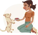 Woman sitting cross-legged on the floor smiling and feeding a small dog with her hand.