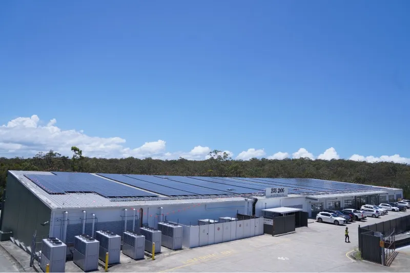 The Big Dog Pet Food factory with solar panels installed on the roof under a clear blue sky.