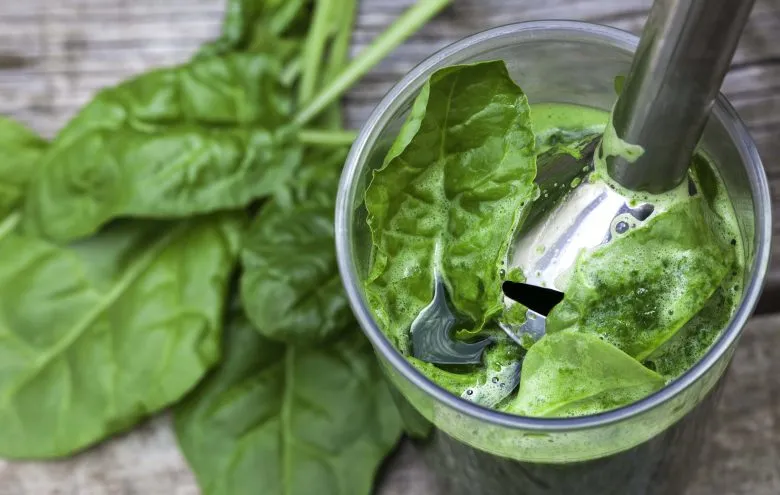 Leafy greens blended to a pulp in a glass. 