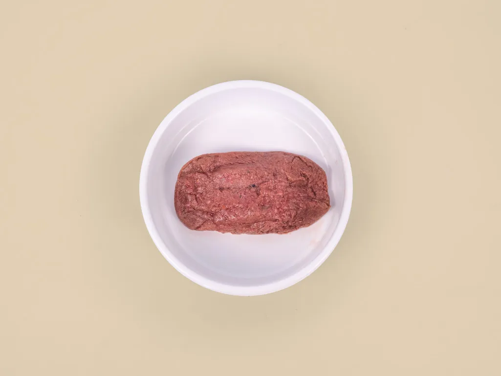 A patty of Beef Raw Cat Food in a bowl.