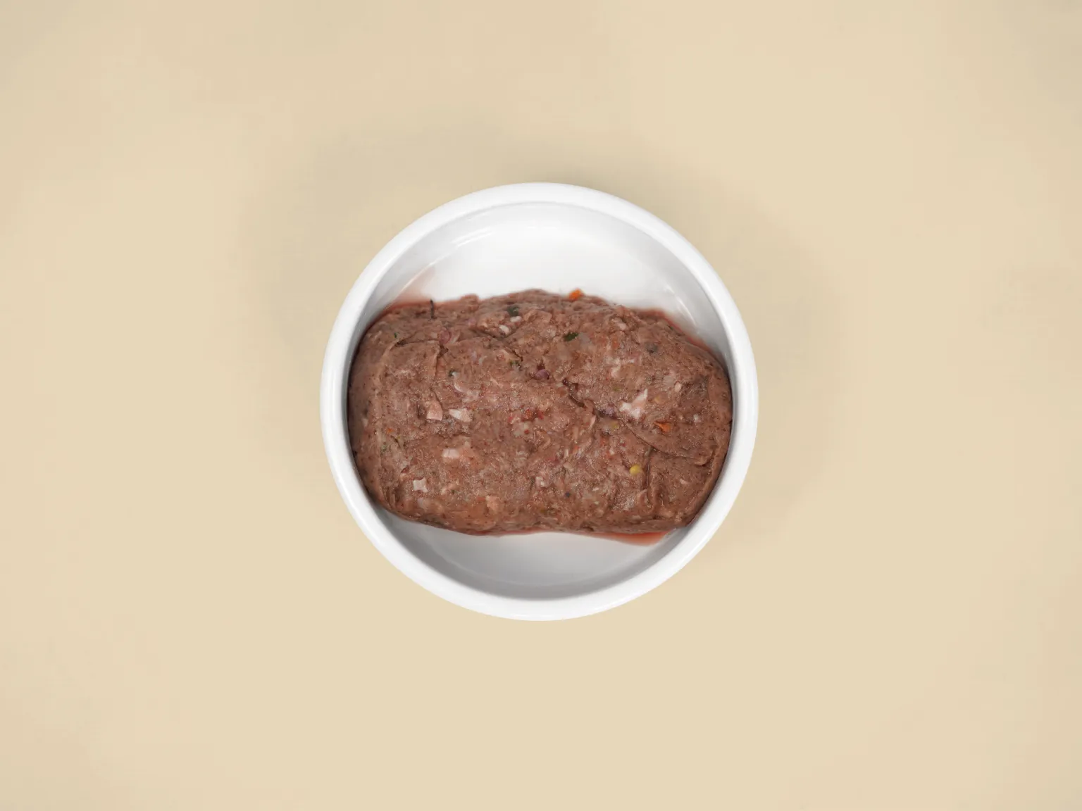 A patty of Combo Raw Dog Food for Small Dogs in a bowl.