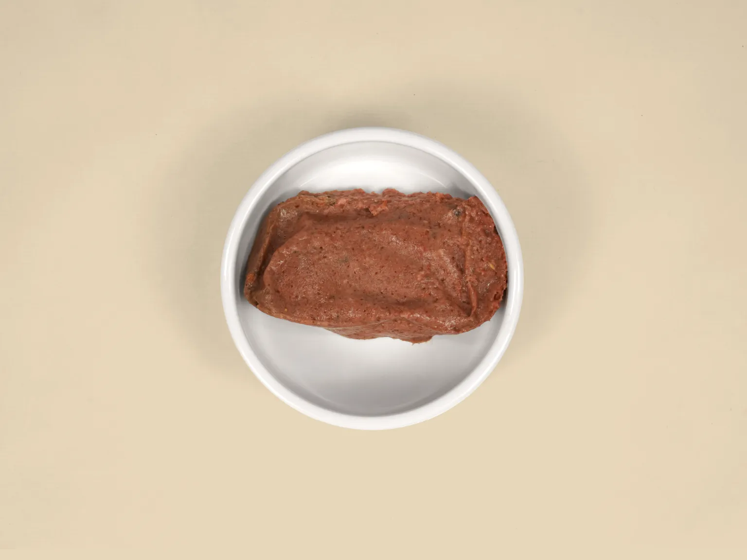 A patty of Chicken Raw Cat Food in a bowl.