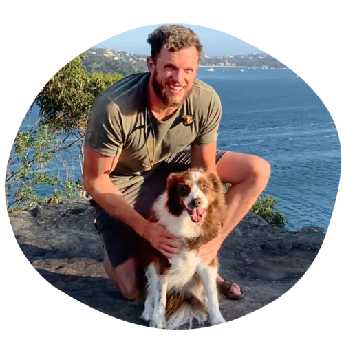 Dr Duncan Houston smiles at the camera while hugging a border collie.