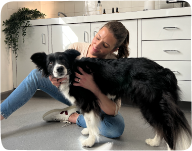 Dr Nicole Rous cuddles a black and white border collie.