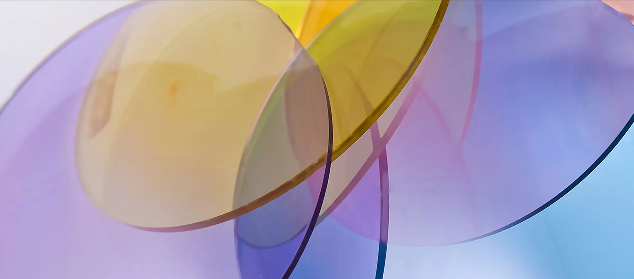 Overlapping translucent circular color filters in shades of purple, yellow, and blue creating gradient effects.