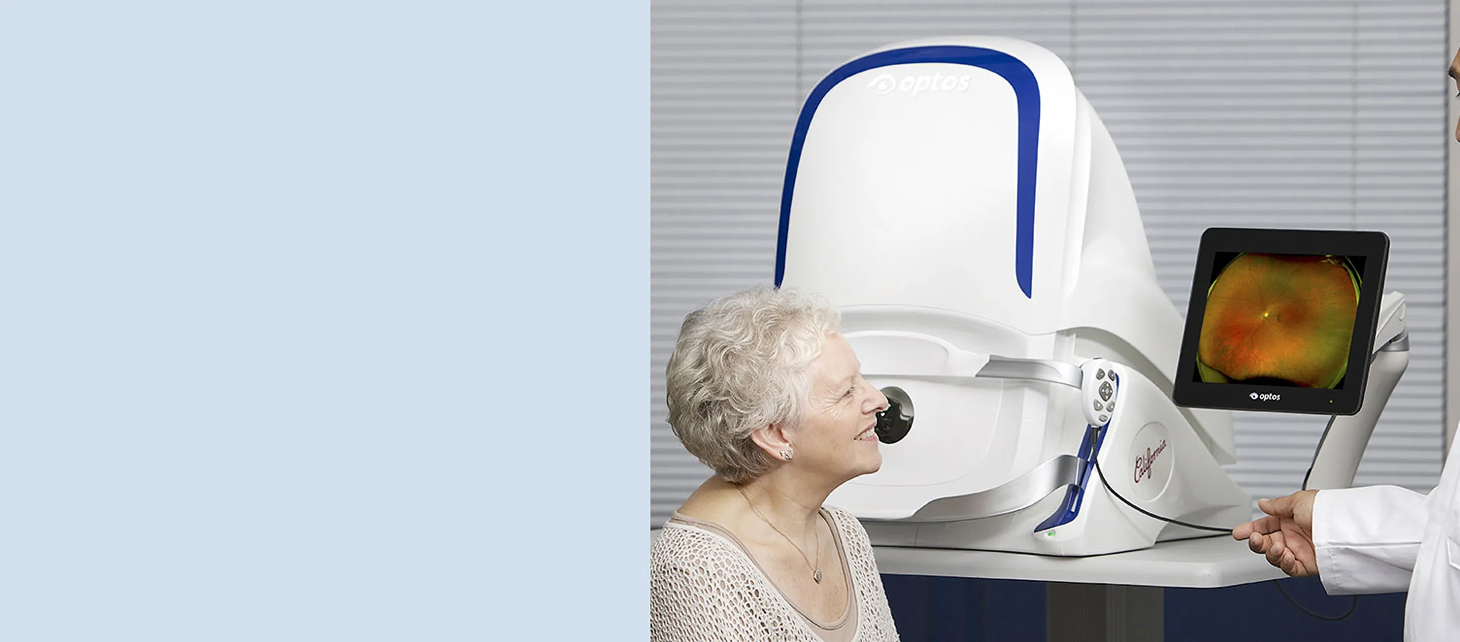 Senior woman undergoing eye examination using an Optos retinal imaging device showing a retina image on a monitor.