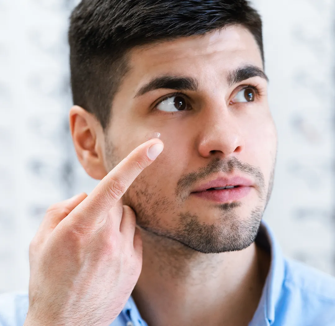 Man inserting soft contact lens for comfortable daily vision correction