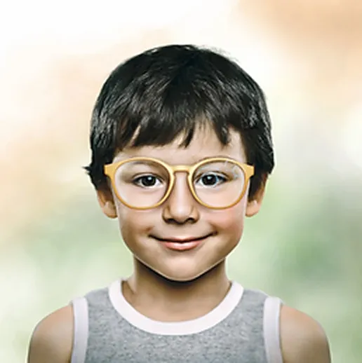 Smiling young boy with short dark hair wearing large round yellow glasses and a gray sleeveless shirt.
