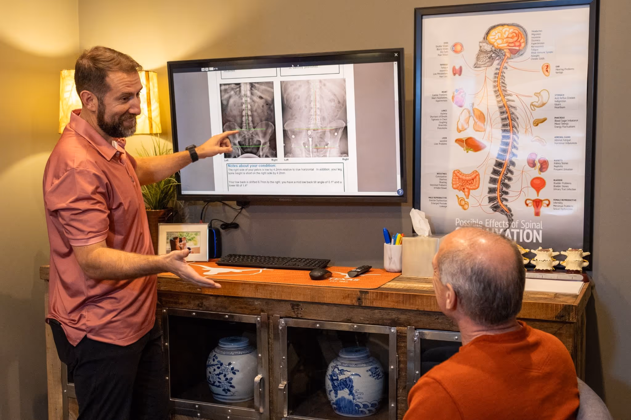 Dr. Ben reviews a patient’s spinal X-rays on a large screen during a consultation, explaining findings and discussing treatment options at Thrive Wellness Center.