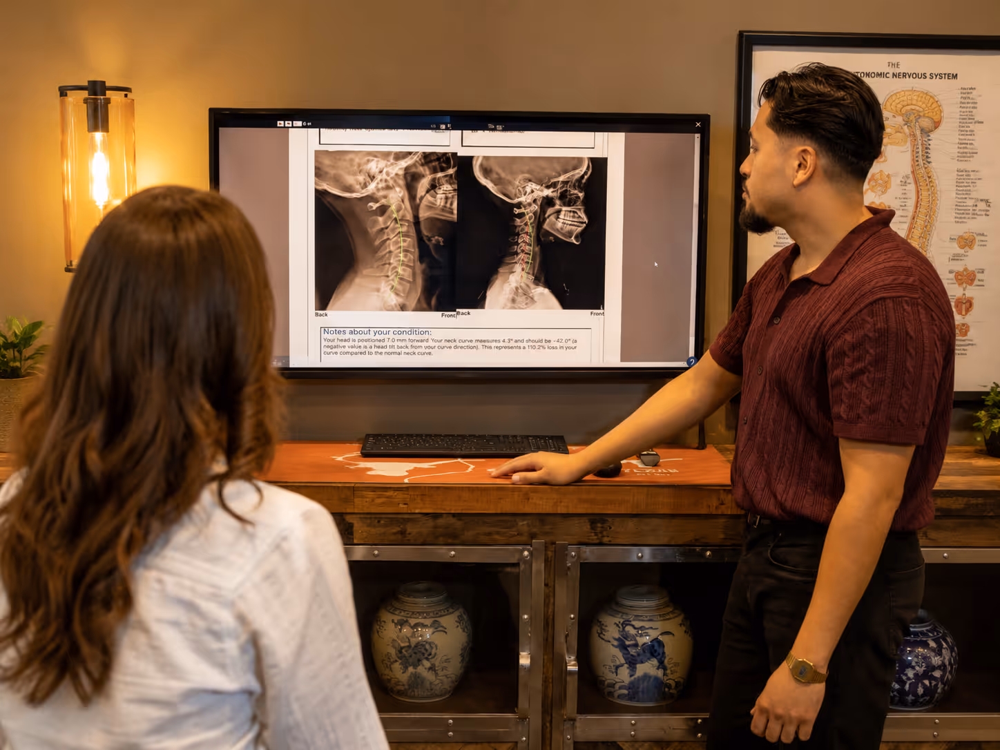 Chiropractor explaining spinal X-ray findings to a patient during a chiropractic consultation.