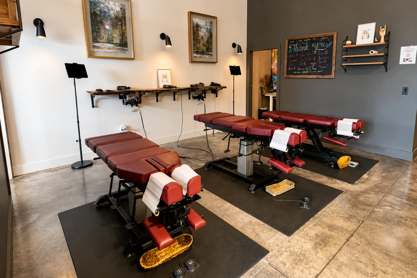 Treatment area at Thrive Wellness Center with multiple chiropractic adjustment tables and equipment.