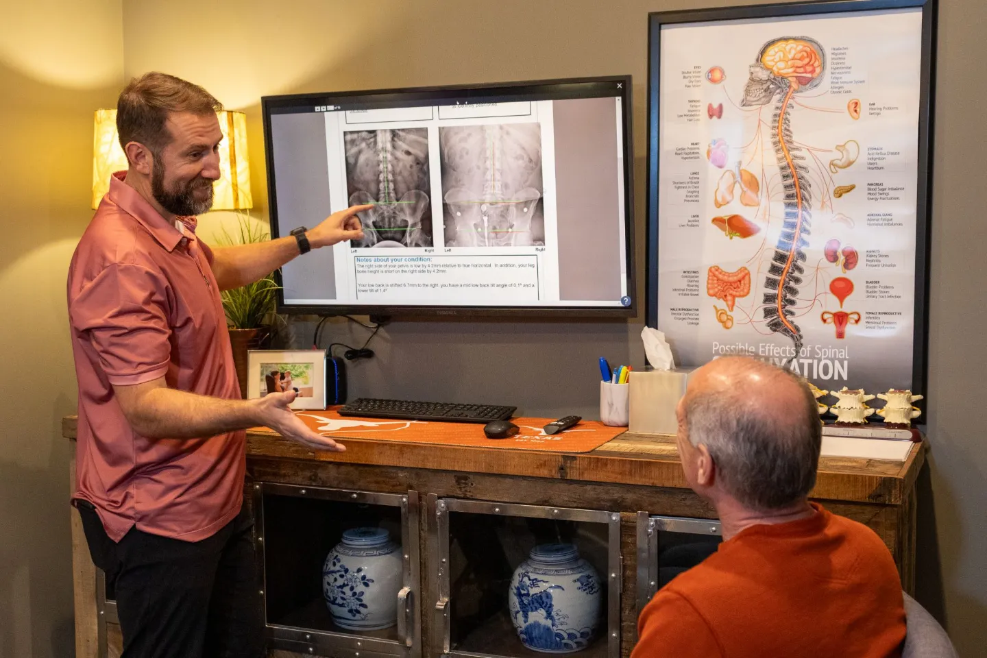 Dr. Ben Ozanne explaining spinal X-ray findings to a patient during an office consultation.