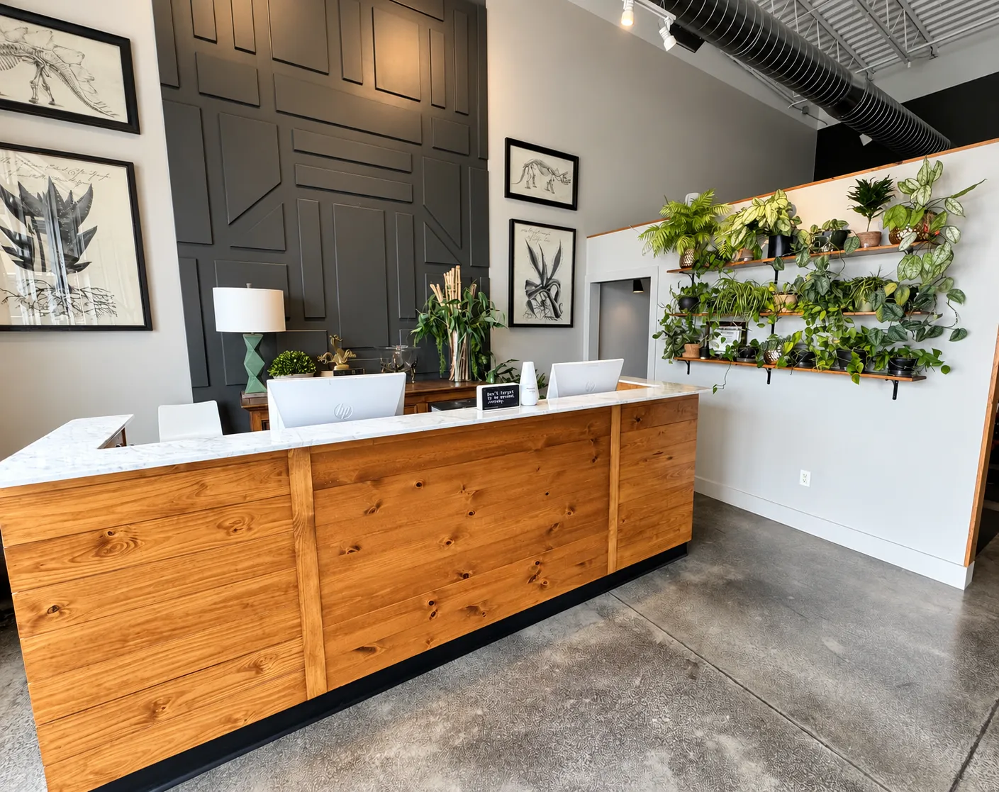Reception area inside Thrive Wellness Center in Fayetteville with a wooden front desk and plant-filled shelves