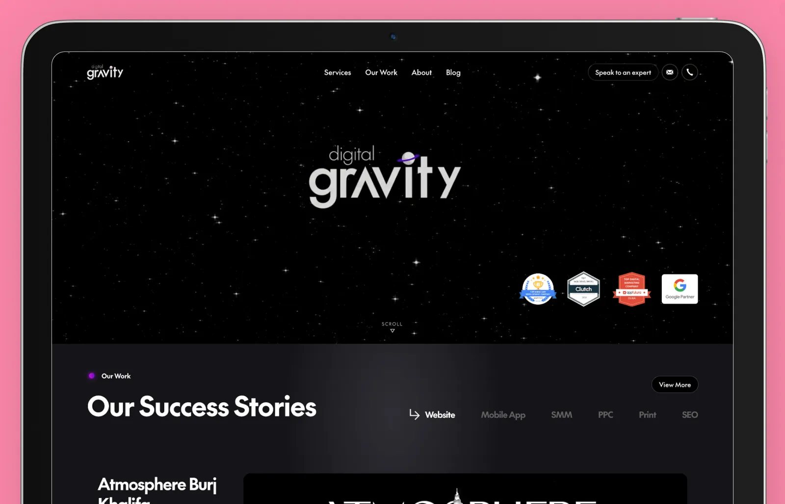 Digital Gravity web design agency website displayed on a tablet screen with a black, space-themed background featuring white stars. The hero section showcases the agency’s logo with a purple planet accent, along with industry recognition badges, including Google Partner and Clutch awards. Below, a section titled 'Our Success Stories' highlights completed projects, emphasizing expertise in website design, mobile app development, and digital marketing. A 'View More' button suggests additional portfolio details.