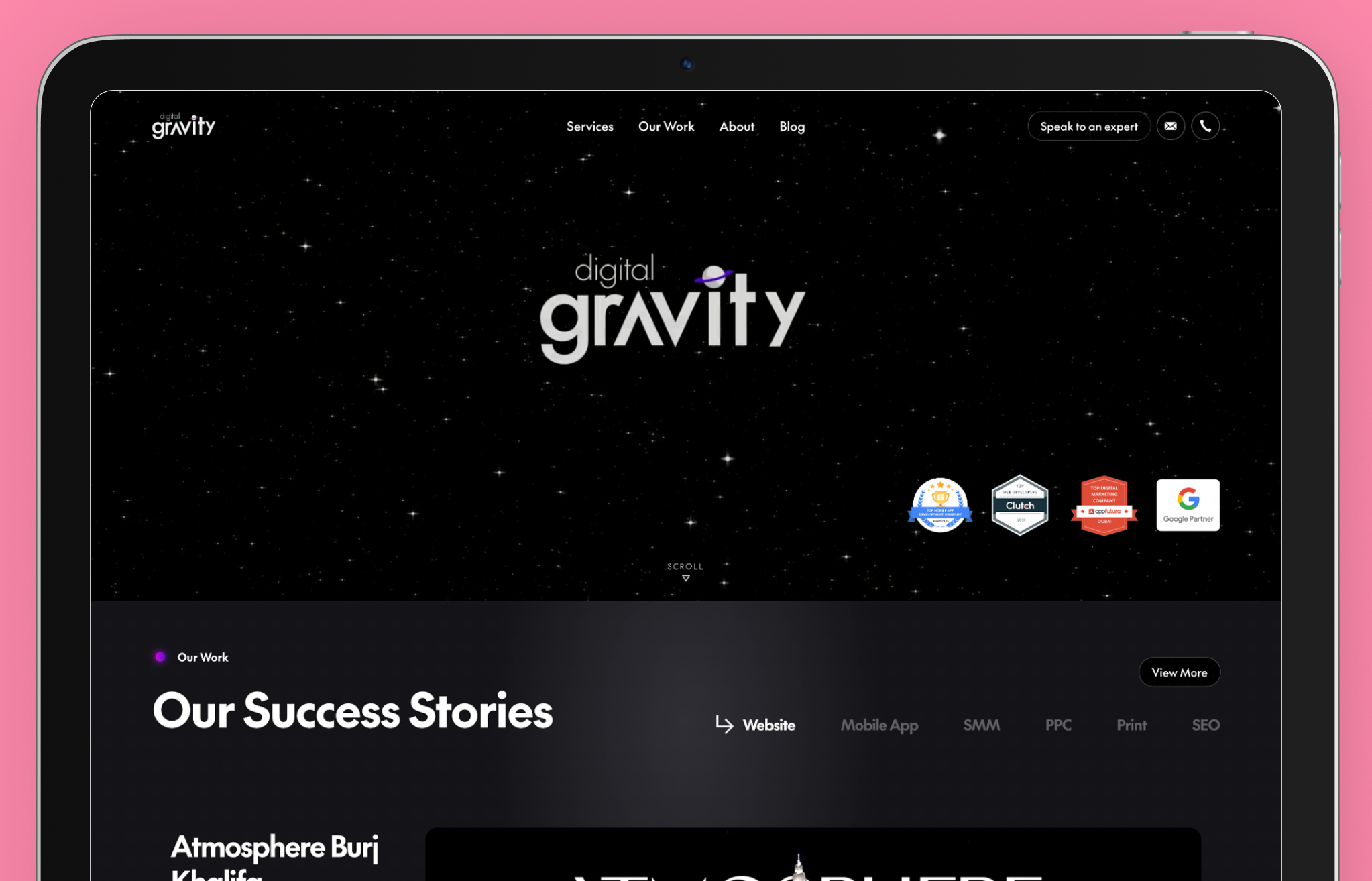 Digital Gravity web design agency website displayed on a tablet screen with a black, space-themed background featuring white stars. The hero section showcases the agency’s logo with a purple planet accent, along with industry recognition badges, including Google Partner and Clutch awards. Below, a section titled 'Our Success Stories' highlights completed projects, emphasizing expertise in website design, mobile app development, and digital marketing. A 'View More' button suggests additional portfolio details.