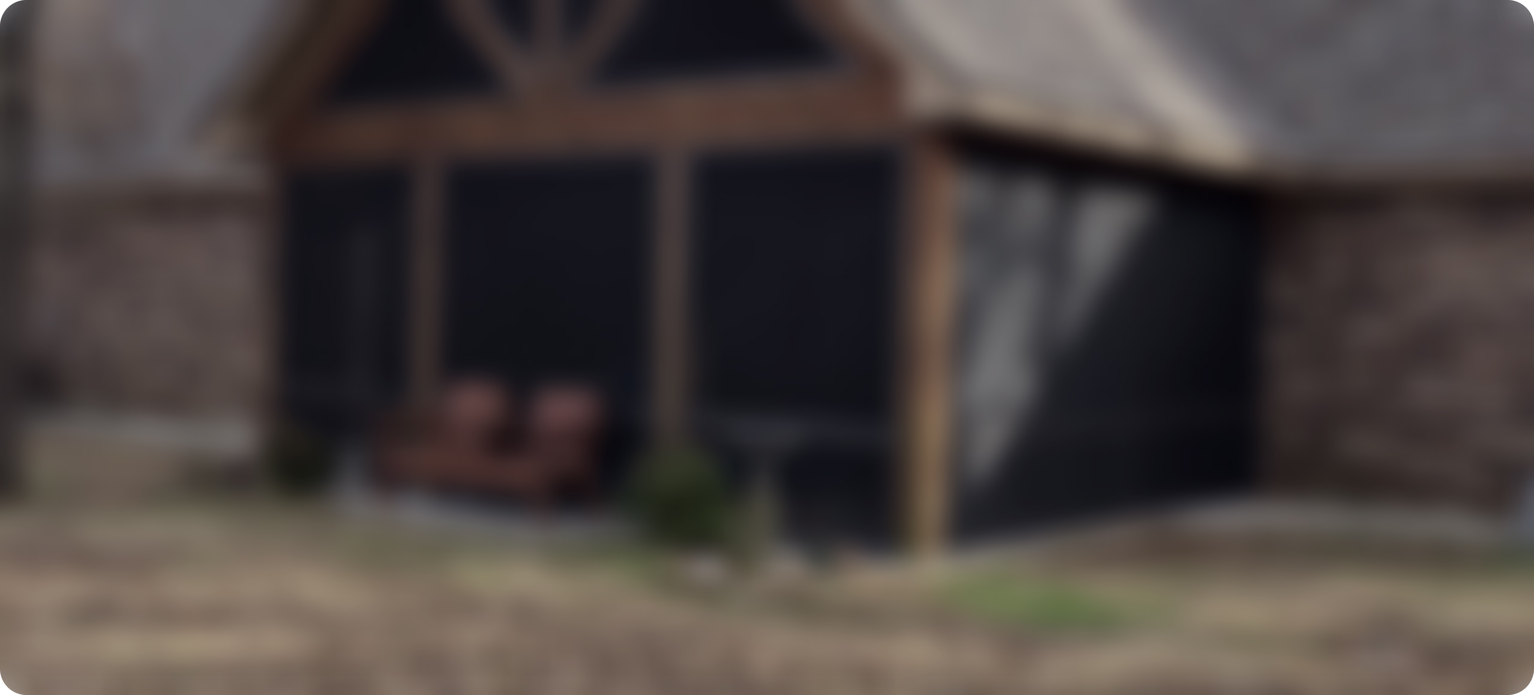 Blurry image of a screened porch with outdoor seating and plants.